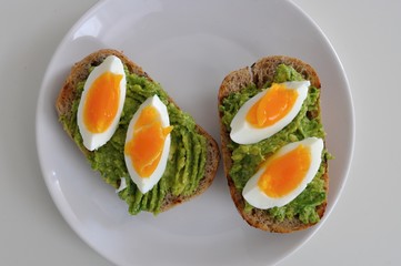 cereal bread with avocado spread and egg on white plate, healthy breakfast, vegetarian food - 191789355