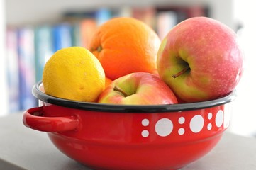 red vintage bowl with white dots including fresh fruits like apples, oranges, lemon, healthy food, vegan diet - 191789363