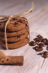 chocolate chip cookies tied with twine with coffee beans and cinnamon stick on white wooden table