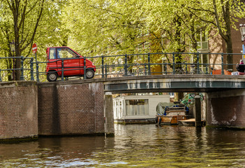 Mini Car crossing a Bridge in Amsterdam canal, Netherlands - 191789703