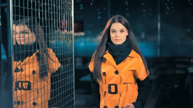 Young fashion woman in leather jacket posing on night city background