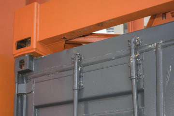 Industrial background with detail of container lifting machine and container in harbor of Rotterdam, Netherlands.