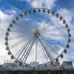 Ferris wheel on blue cloudy sky background at Scheveningen beach near the Hague, Netherlands.
