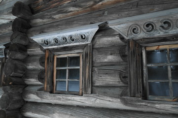 окна с деревянными рамами и наличниками в старом , деревянном доме - obrazy, fototapety, plakaty