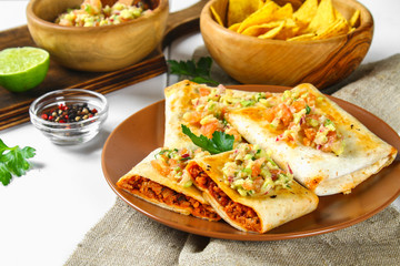 Traditional Mexican dish - chimichanga. Corn cake with minced meat, pepper, onion, garlic, oregano, zira and guacomole sauce from avocado.
