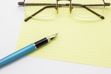 eyeglasses and pen on book isolated on white background