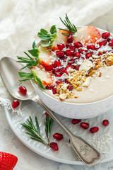 Healthy smoothie bowl of strawberries, pomegranate and almonds.