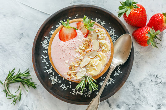 Healthy Pink Smoothie Bowl Of Strawberries, Banana, Nuts And Yogurt.