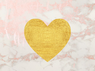 Gold heart on pink marble background. 