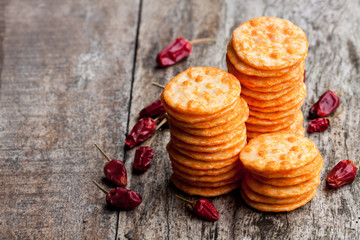 Round  shape rice cracker with chili pepper on wooden table