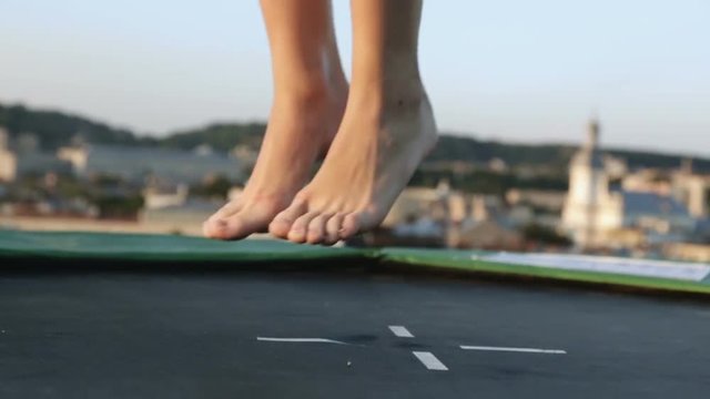 closeup woman athletic feet barefoot legs jumping trampoline outdoor healthy strong naked sports body active leaps trendy active lifestyle training fitness fit activity human selective focus sunny day
