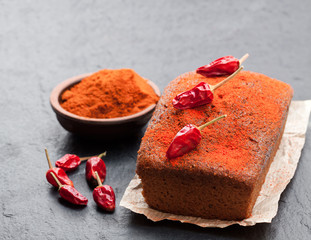 Delicious  chocolate cake with chili pepper on black stone background