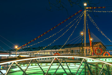 Obraz premium Colorful ship with festive lights frozen in river. Restaurant on water at winter. Atmospheric feeling in city Jelgava at Christmas time.
