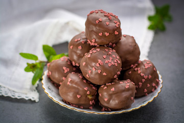 Valentine's Day concept, chocolate profiteroles with pink hearts, stuffed cakes,  special romantic event.