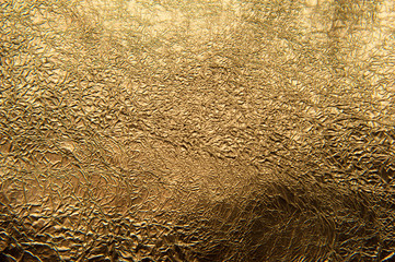 Texture of crumpled golden foil. Metallic background