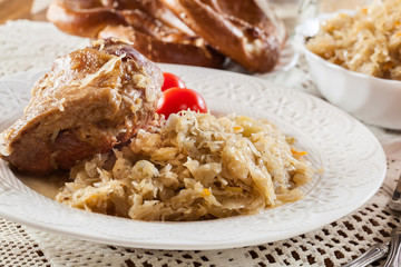 Pork knuckle with fried sauerkraut and tomatoes