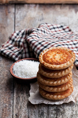 Stack  of coconut tarts on wooden table