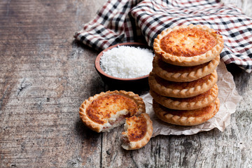 Stack  of coconut tarts on wooden table