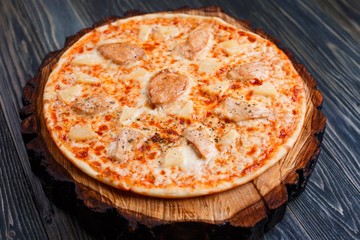 Freshly baked pizza with chicken and pineapple, close up. Delicious Italian food