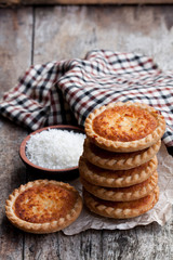 Stack  of coconut tarts on wooden table
