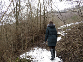 Girl walks in the winter mountain forest