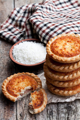 Stack  of coconut tarts on wooden table