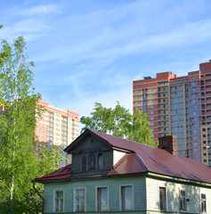 Old wooden house and modern buildings.