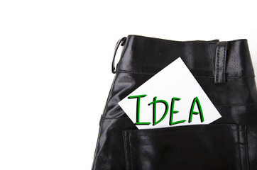 Idea on white paper in the pocket of leather trousers