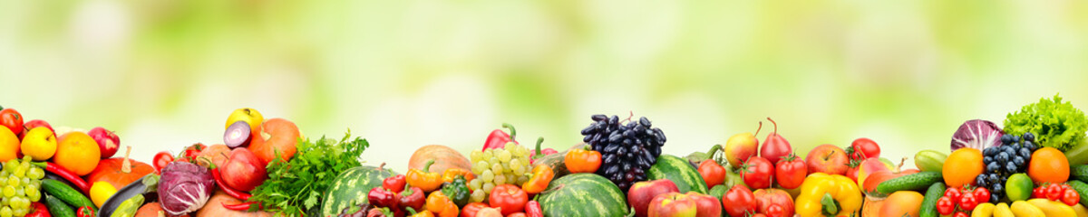 Panoramic collection fresh fruits and vegetables on green background.