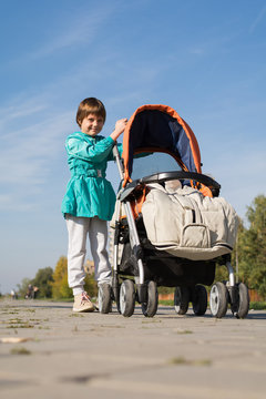 sister walking with young brother in stroller