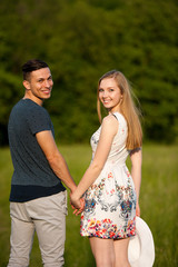 Obraz premium Active young couple on a wlak in the park on hot summer afternoon