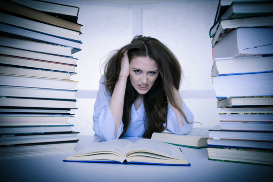 attractive young woman student undre stress while studiing for exames