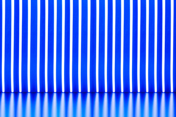 Abstract background with neon glow/ Abstract background with neon glow sticks and their reflection on a blue background.