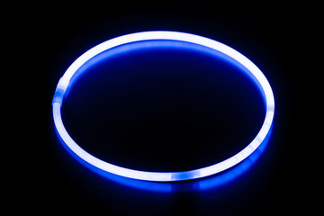 Round blue glow stick bracelet/ Round blue glow stick bracelet on a black surface with reflection