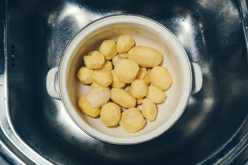 Washed potato/ Washed cleaned raw potatoes in a saucepan in a sink