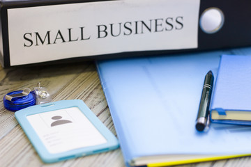 Planning business concept - small business documents, notepad and a pass. Rough bords background. Closeup