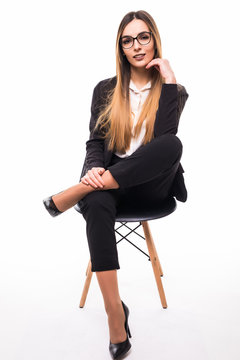 Full Length Portrait Of A Young Business Woman In Glasses Sitting In Chair Over White Background