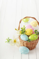 basket with easter eggs and flowers