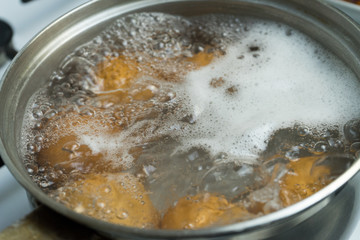 Chicken eggs boil in water. Pan with the product on a gas stove.