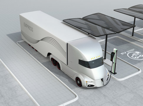 Silver self-driving electric truck charging at charging station. 3D rendering image.