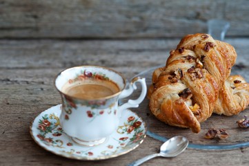 Danish pastry maple pecan with nuts and a cup of coffee, breakfast
