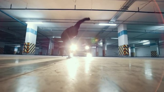 Young stylish man freerunner performing a handstand, parkour acrobatic elements, slow motion
