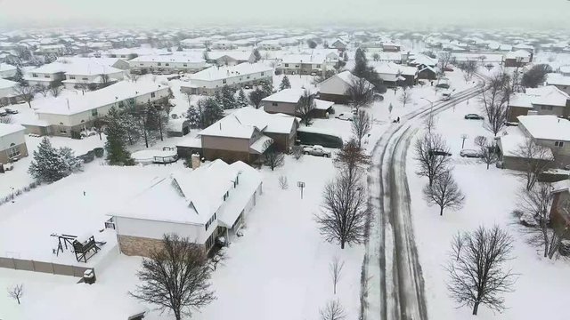 4k Aerial view of United States Postal Service delivering mail on a cold snowy winter day