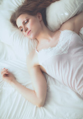 Obraz na płótnie Canvas Pretty woman lying down on her bed at home.