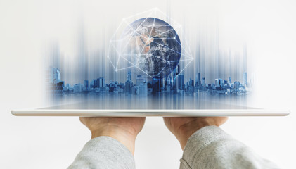 Hand holding digital tablet with global network connection technology and modern buildings hologram. Element of this image are furnished by NASA
