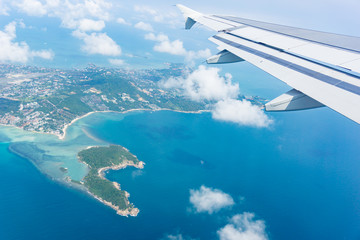 Fototapeta premium Flying away from Ko Samui from plane window island and sea below.