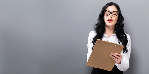 Office woman with a clipboard on a solid background