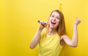 Young woman with party theme on a yellow background