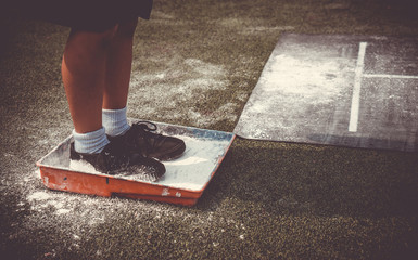 Students boy wait for queue and prepare himself for taking long jump on flour powder mark on sport competition day. School sports day competition activities concept for background.