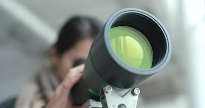 Woman looking though the telescope